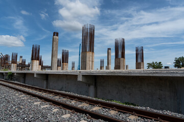 Concrete columns under construction at a railway development site with exposed steel...