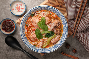Luosifen is a speciality Chinese noodle in a white cup Contains Rice vermicelli, With Sichuan pepper soup seasoned with vinegar for a delicious taste.