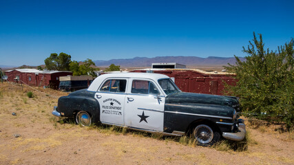 Vintage car with Radiator sprrings police car banner at display along the mother road, route 66.
