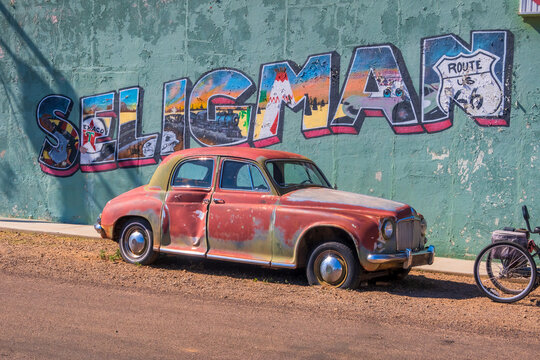 Vintage car in front of a store with Seligman road sign on the wall in Arizona.