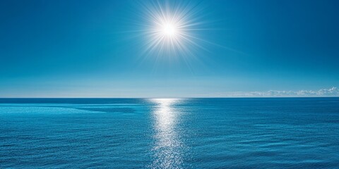Obraz premium Bright sun shines over calm blue ocean water.