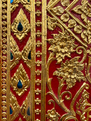 Close up of Thailand temple engraving and mural art pattern on wall, in different shapes, forms, and carved in every details, in red and gold colors. Seamless background texture. 