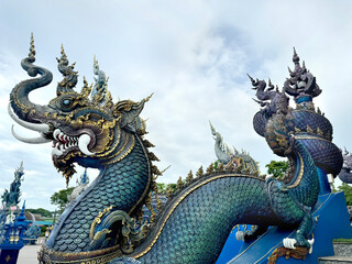 Obraz premium Dragon statue at the entrance of Blue Temple or Wat Rong Suea Ten, Chiang Rai, Thailand. Painted in all shades of blue and tosca color.