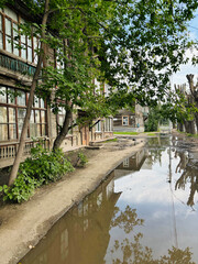 Fototapeta premium Summer urban landscape Russia Novosibirsk. The broken sidewalks are covered with water