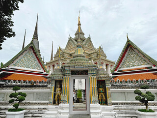 Fototapeta premium Beautiful door way gate inside the Wat Pho and the Grand Palace Complex, Bangkok, Thailand. With its ornaments, Buddhist engravings, and Thai architecture.