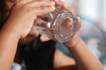 A Young Child Enjoying a Glass of Refreshing Water in Bright, Inviting Natural Light