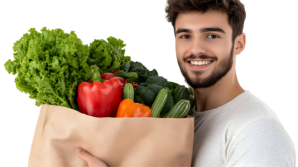 Man holding a brown paper bag filled with fresh vegetables, such as lettuce, red bell pepper, broccoli, and cucumbers, isolated on transparent background.