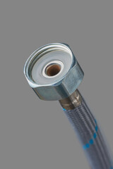 braided stainless steel water hose end connector isolated gray background in close-up view, high...