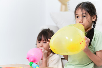 Fototapeta premium Kids girl playing with balloons, Asian children playing with balloons in living room