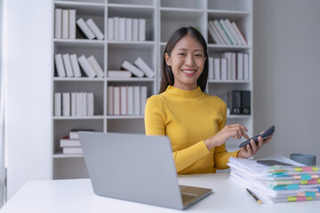 woman meticulously plans a finance audit, using a computer and calculator to review budget...