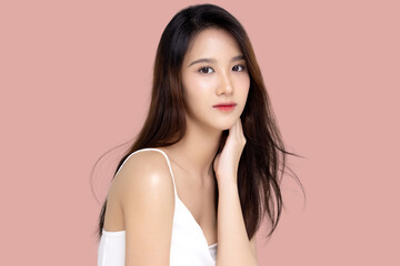 Beautiful young Asian woman with K beauty style makeup and perfect skin on isolated pink background. Facial and skin care concept for commercial advertising.