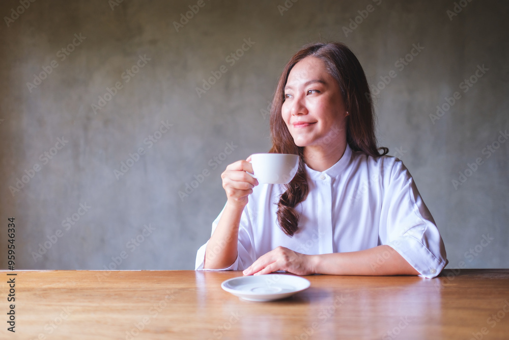 Wall mural portrait image of a beautiful young asian woman holding and drinking hot coffee