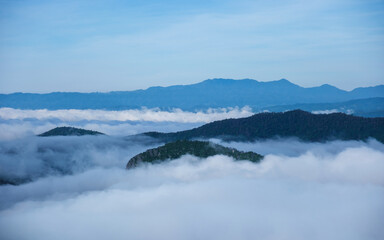 Landscape image of mountains peak with sea of clouds and blue sky
