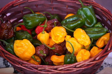 The hot peppers are in a wicker basket.