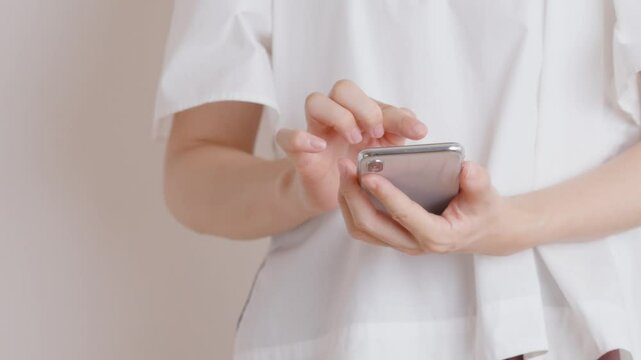 Woman looking at smartphone. Woman scrolling through her smartphone. スマホを見ている女性。スマートフォンをいじったり、スクロールしている女性。