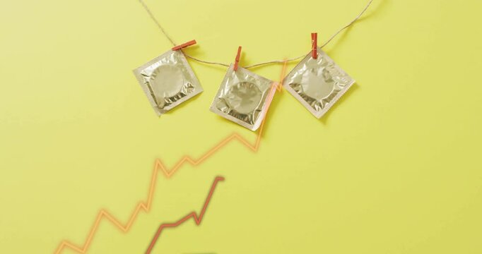 Condoms hanging on string with clothespins over rising graph animation on yellow background