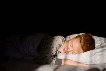 Child sleeps in bed at dawn