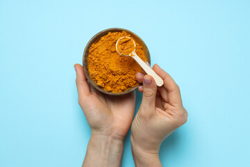 Turmeric powder in a bowl on a blue background