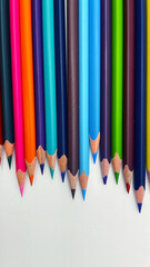 Colorful sharpened pencils are lined up on the table.