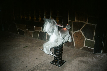 A vintage spring-mounted playground horse, weathered and worn,