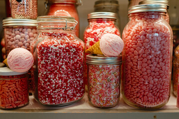 Jars filled with various pink candies and sprinkles