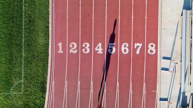 Female runner walking up to start line and sprinting