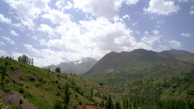 A mountain range with a clear blue sky and a few clouds