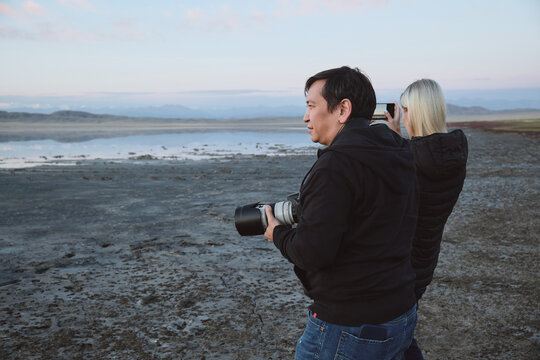 Photographers Taking Pictures by a Scenic Lake at Dusk.