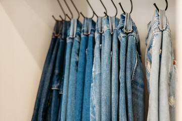 Jeans hanging on hooks organized in closet
