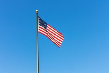 Obraz premium American flag waving against clear blue sky