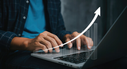 Person using laptop and working with growing graph with upward trend arrow. Business data analytics concept.