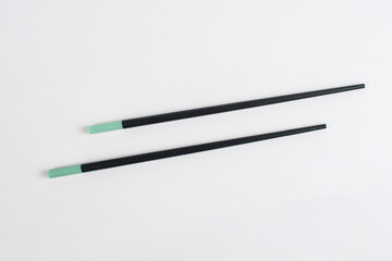 Fototapeta premium Black chopsticks for rice on a white background