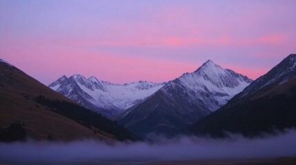 A stunning panoramic view of snow-capped mountains at sunrise with a blanket of fog covering the valley.