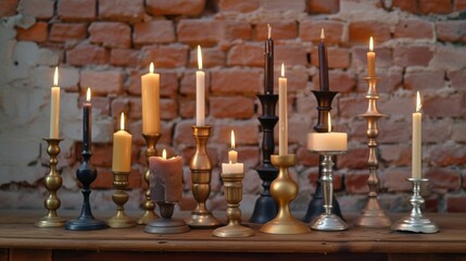A diverse collection of candles in various holders is displayed on a wooden table, set against a rustic brick wall. The warm candlelight creates a serene and cozy atmosphere, perfect for home decor or