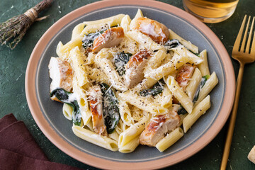 Pasta alfredo with chicken, spinach and cheese. Italian food.