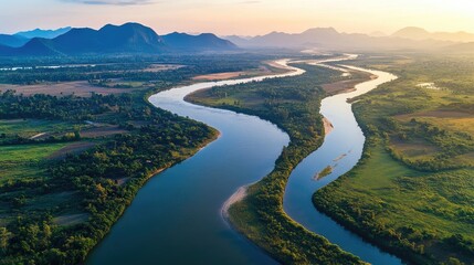 Aerial shot of the Mekong River as it winds through Thailand's northern landscapes, with mountains in the distance.