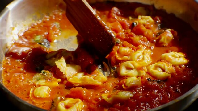 Delicious tortellini simmering in rich tomato sauce on stovetop
