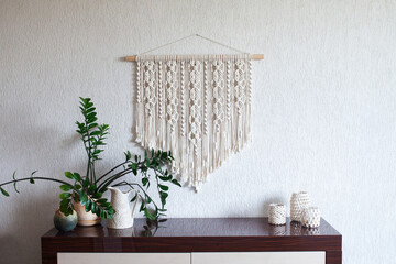 Macrame wallhanging in the interior. ECO friendly modern knitting DIY natural decoration concept. Female hobby. 100% cotton handmade. .