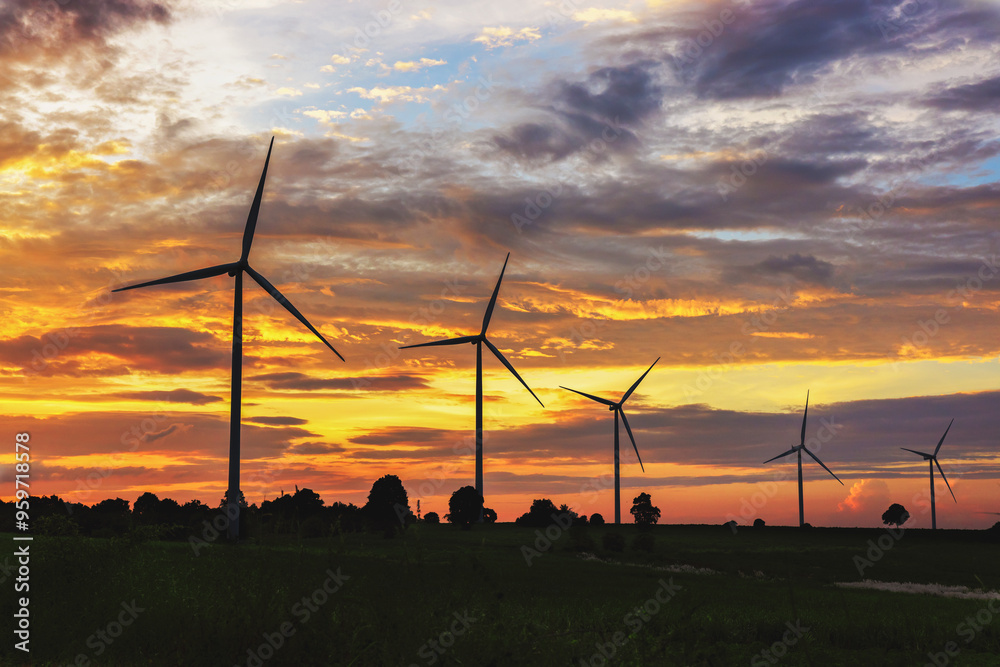 Wall mural field of wind turbines with the sun setting in the background