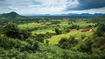 Fototapeta premium Top view of Oudongas countryside, with green fields and ancient stupas visible in the distance.