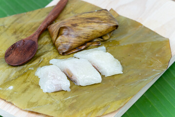 Stir-fried rice porridge or Khao Tom Pad is made from sticky rice stuffed with ripe bananas and wrapped in banana leaves before steaming. The Thai dessert is placed on banana leaves and ready to eat.