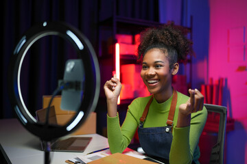 American female freelance worker African live selling products online business Using a mobile phone...