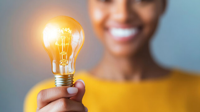 A close up photo of persons hand holding light bulb, symbolizing creativity and inspiration. bright light bulb shines brightly, reflecting positive and innovative spirit.