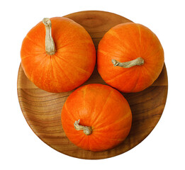 composition of three pumpkins on a wooden plate top view on a white background.