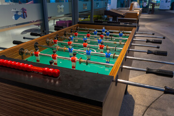 Fototapeta premium Retro table soccer with wooden miniature figurines of players on metal bars, mini soccer table game. table football soccer game.