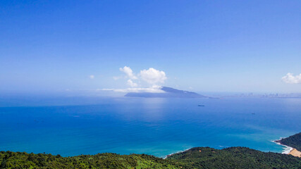 Scenic beach and mountainous coastline under clear blue sky, perfect for tropical getaways and nature retreats during summer holidays