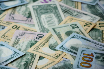 Big amount of US dollar bills in different nominations on table. Many dollar banknotes under natural light