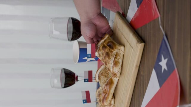 Fiestas Patrias Chile taking out a Empanada and chilean flags and wine glasses