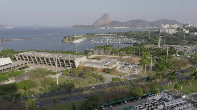 Rio de Janeiro, Brazil - August 2024: Museum of Modern Art (MAM), seat of the G20 Summit 2024 - aerial approaching the MAM past aterro do flamengo road with Gloria marina and Sugarloaf Mountain in the