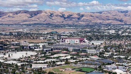 Levi's Stadium aerial view with the surrounding Silicon Valley landscape and distant hills under a clear sky in Santa Clara, California. Perfect for showcasing California's urban and natural scenery